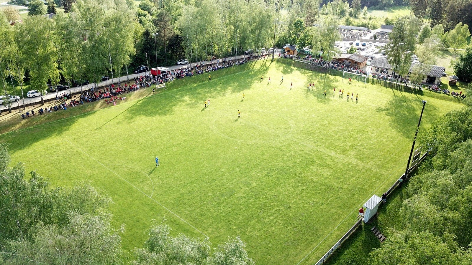 Luftaufnahme des Sportplatzes waehrend eines Spiels